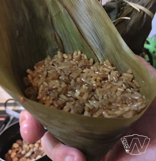 Topping up pre-fried rice onto the Bak Chang cone folded bamboo leaves