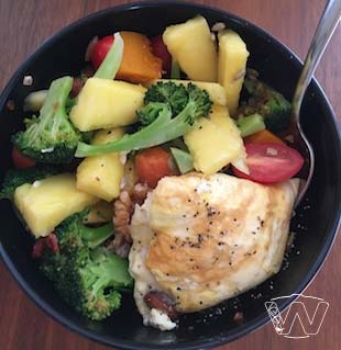 Salad bowl of pan fried egg, broccoli, cherry tomato, walnuts