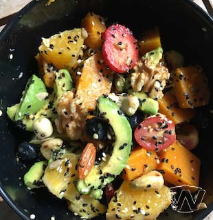 Salad bowl of orange, strawberry, papaya, walnuts, pumpkin seeds, avocado