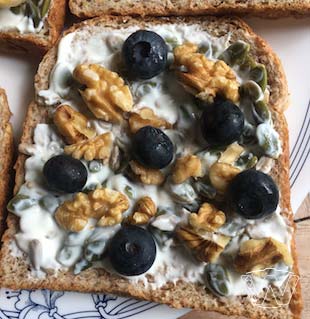 Wholemeal sandwich with yogurt spread and walnuts, blueberry toppings